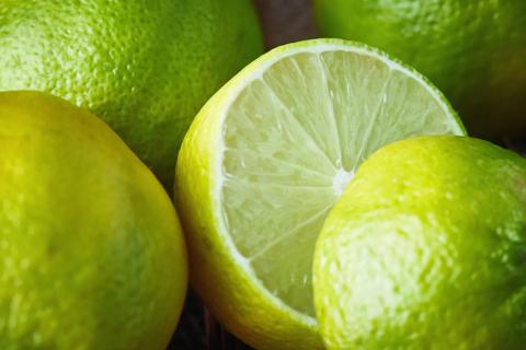 A sliced open lime among whole limes