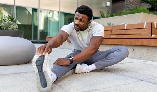 Person outside on patio stretching their hamstring